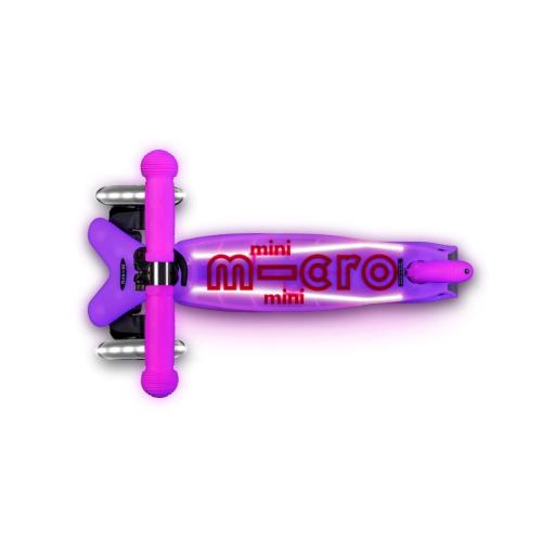 Scooter Mini Micro Deluxe Glow LED Frosty Pink rosado con tres ruedas luminosas, manubrio ajustable y detalles que brillan en la oscuridad.