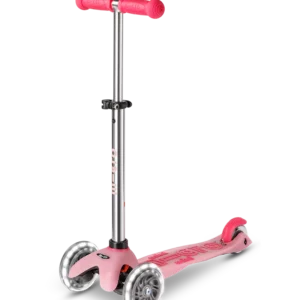 Scooter Mini Micro Deluxe Glow LED Frosty Pink rosado con tres ruedas luminosas, manubrio ajustable y detalles que brillan en la oscuridad.